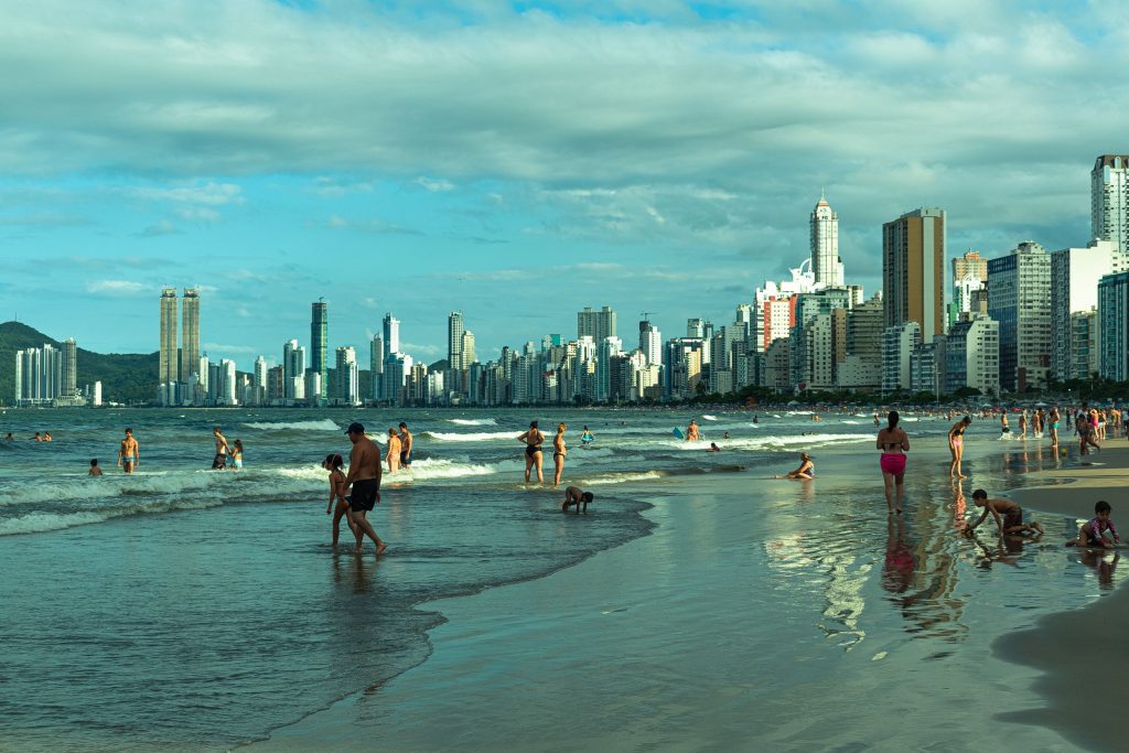Famílias e crianças na Praia Central de Balneário Camboriú com o skyline ao fundo